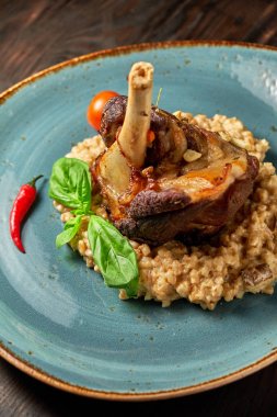 Mavi bir tabak üzerinde bir garnitür ile Knuckle et çanak. Koyu ahşap arka plan.