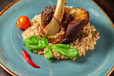 Mavi bir tabak üzerinde bir garnitür ile Knuckle et çanak. Koyu ahşap arka plan.