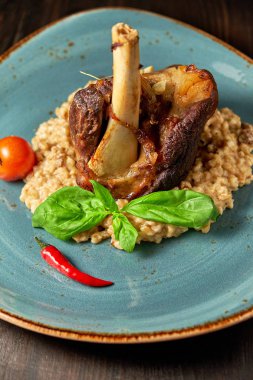 Mavi bir tabak üzerinde bir garnitür ile Knuckle et çanak. Koyu ahşap arka plan.