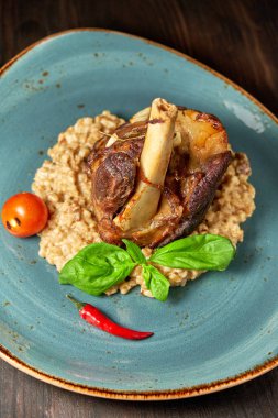 Mavi bir tabak üzerinde bir garnitür ile Knuckle et çanak. Koyu ahşap arka plan.