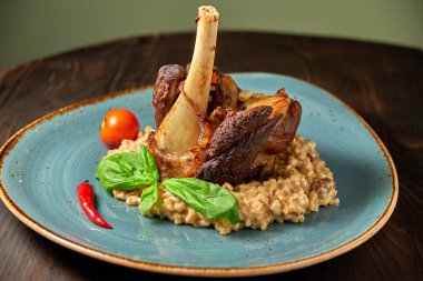 Mavi bir tabak üzerinde bir garnitür ile Knuckle et çanak. Koyu ahşap arka plan.