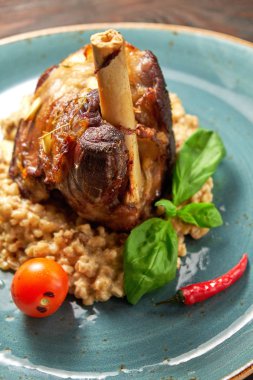 Mavi bir tabak üzerinde bir garnitür ile Knuckle et çanak. Koyu ahşap arka plan.