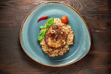 Mavi bir tabak üzerinde bir garnitür ile Knuckle et çanak. Koyu ahşap arka plan.