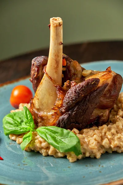 Mavi bir tabak üzerinde bir garnitür ile Knuckle et çanak. Koyu ahşap arka plan.