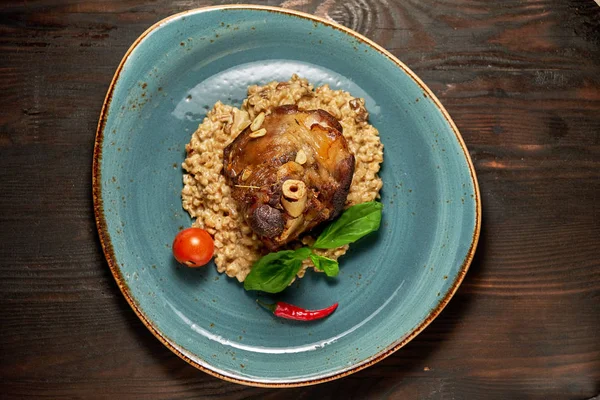 Mavi bir tabak üzerinde bir garnitür ile Knuckle et çanak. Koyu ahşap arka plan.