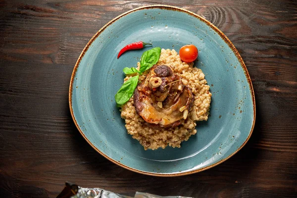 Mavi bir tabak üzerinde bir garnitür ile Knuckle et çanak. Koyu ahşap arka plan.