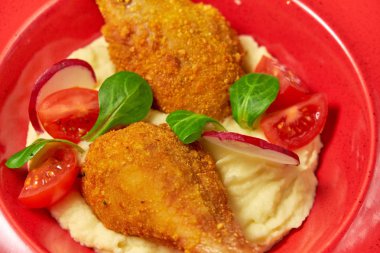 Tavuk bacakları yanında patates püresi var. Açık ahşap arka plan. Restoran menüsü