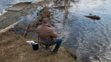 Olgun adam nehirde balık yakalar.
