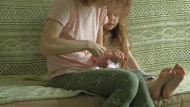 Frau schneidet Kind die Nägel — Stockvideo