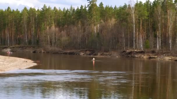 Люди гребут по реке в облачную погоду . — стоковое видео