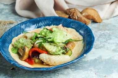 Kalamarlı sebze salatası. Güzel servis yemekleri. Açık gri arka plan. Restoran menüsü