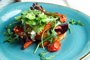 Arugula, biber, pancar ve domates ile Sıcak sebze salatası. Güzel servis yemekleri. Açık gri arka plan. Restoran menüsü