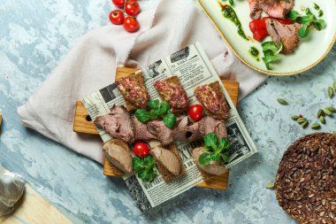 Soğuk etli atıştırmalıklar. Güzel servis yemekleri. Açık gri arka plan. Restoran menüsü