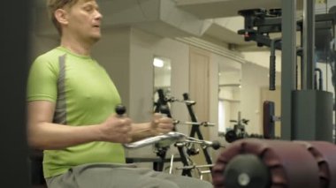 Kilolu adam, spor salonunda daha az istek, sırt egzersizleri paylaşıyor. Fitness. Sağlıklı yaşam tarzı