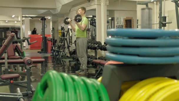 Nadwagą człowiek podnosi EZ Brzana stojąc na siłowni. Ćwiczenia dla biceps. Fitness. Zdrowy styl życia. — Wideo stockowe