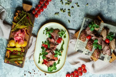 Salamura sebze ile soğuk et aperatifler. Yemeklerin güzel bir porsiyon. Açık gri arka plan. Restoran menüsü