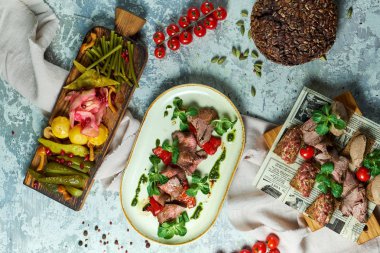 Salamura sebze ile soğuk et aperatifler. Yemeklerin güzel bir porsiyon. Açık gri arka plan. Restoran menüsü