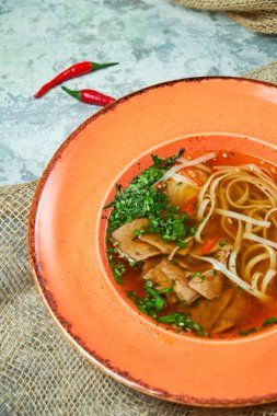 Açık gri dokulu arka planda erişte ve sığır çorbası. Güzel servis yemekleri. Restoran menüsü