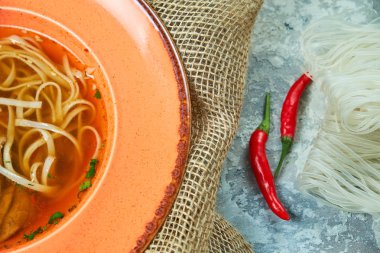 Açık gri dokulu arka planda erişte ve sığır çorbası. Güzel servis yemekleri. Restoran menüsü