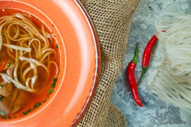 Açık gri dokulu arka planda erişte ve sığır çorbası. Güzel servis yemekleri. Restoran menüsü