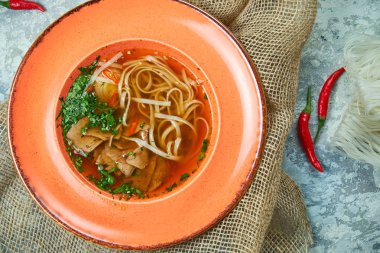 Açık gri dokulu arka planda erişte ve sığır çorbası. Güzel servis yemekleri. Restoran menüsü