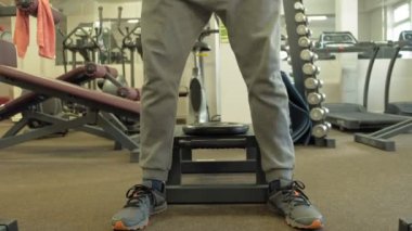 Kilolu adam bir halter için bir ağırlık diski ile squats ile çömelme yok. Fitness eğitimi. Sağlıklı yaşam tarzı kavramı