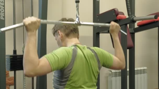 Nadwagą człowiek dzieli górny blok w siłowni. Fitness. Zdrowy styl życia. — Wideo stockowe
