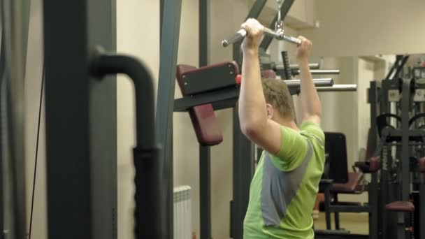 The overweight man shares the upper block in the gym. Fitness. Healthy lifestyle. — Stock Video