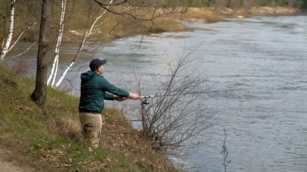 Homme mûr capture des poissons sur la rivière . — Video