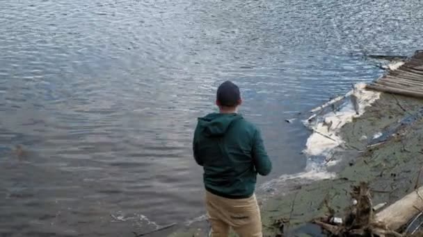 Hombre maduro atrapa peces en el río . — Vídeo de stock