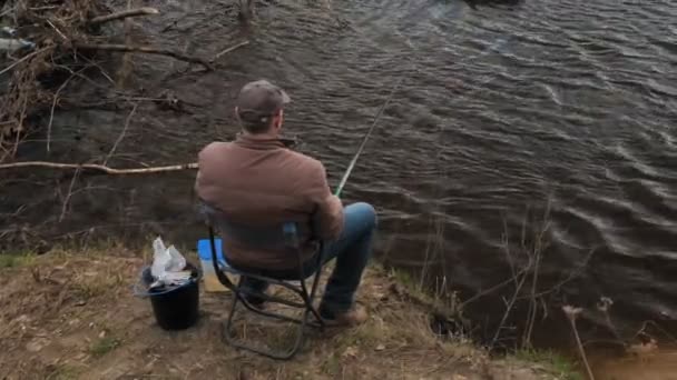 Mogen man fångar fisk på floden. — Stockvideo