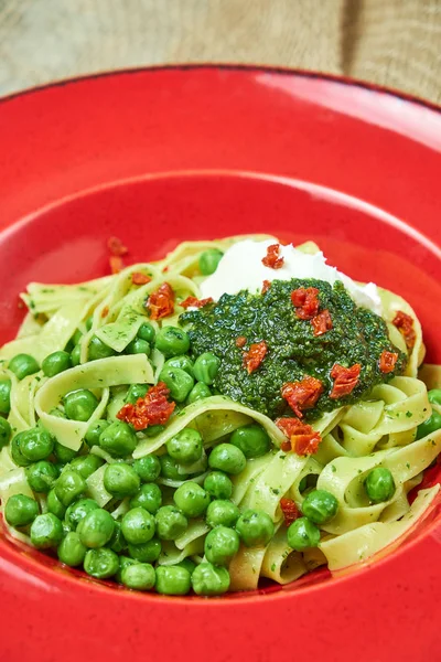 Спагетті зі свіжим зеленим горошком. Сірий текстурований фон з бежевою тканиною. Гарна подача посуду. Меню ресторану — стокове фото