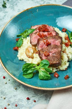 Biftekli beyaz pirinç. Rizzotto. Gri ışıklı arka plan. Güzel yemek servisi.