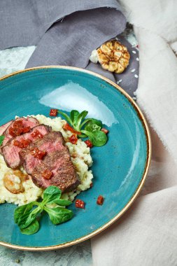 Biftekli beyaz pirinç. Rizzotto. Gri ışıklı arka plan. Güzel yemek servisi.