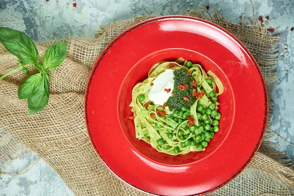 Spaghete cu mazăre verde proaspăt. Fundal gri texturat cu țesătură bej. Frumoasă servire de feluri de mâncare. Meniu restaurant — Fotografie, imagine de stoc