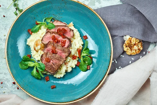 Biftekli beyaz pirinç. Rizzotto. Gri ışıklı arka plan. Güzel yemek servisi.