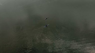 Nehirdeki mavi kanodaki atletler. Sağlıklı yaşam tarzı. Aktif spor. Drone ile hava çekimi.