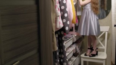 Güzel küçük kız ev gardırop elbise seçer. Güzellik ve moda