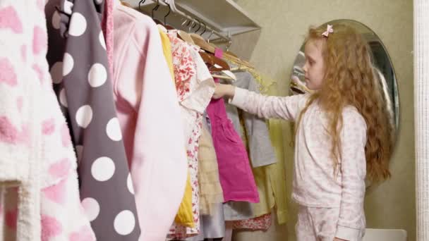 Όμορφο κοριτσάκι επιλέγει φόρεμα στο σπίτι ντουλάπα. Ομορφιά και μόδα — Αρχείο Βίντεο
