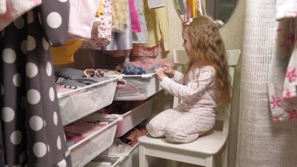 Hermosa niña en el armario del hogar. Niños de moda — Vídeo de stock