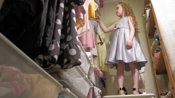 Mooi klein meisje kiest jurk in Home garderobe. Schoonheid en mode — Stockvideo