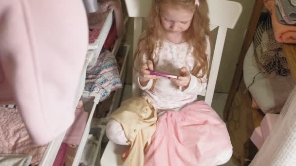 Beautiful little girl uses the phone — Stock Video