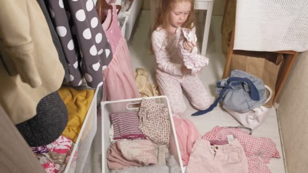 Niña limpia la ropa en el armario del hogar — Vídeos de Stock