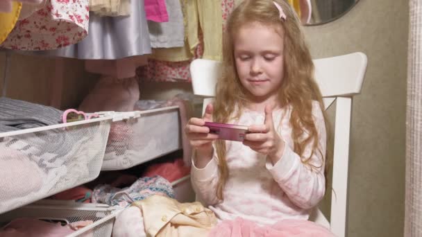 सुंदर छोटी लड़की फोन का उपयोग करती है — स्टॉक वीडियो