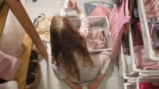 Klein meisje ruimt kleren in thuis garderobe — Stockvideo