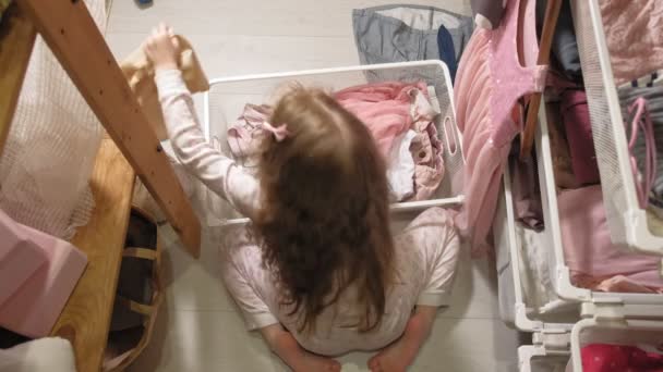 La bambina pulisce i vestiti nel guardaroba di casa — Video Stock