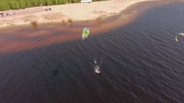 Människor på floden på sommaren ägnar sig åt kitesurfing. Extrem sport — Stockvideo