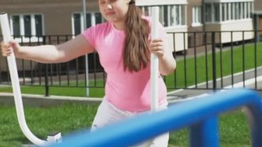 Egzersiz ekipmanları ile açık sitede genç kız. sağlıklı yaşam tarzı