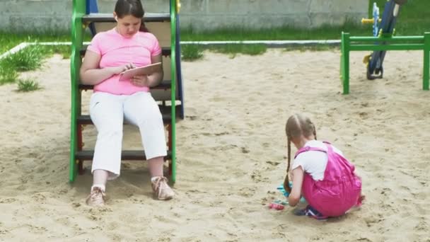 Τα παιδιά χρησιμοποιούν tablet υπολογιστή, περπατούν στην παιδική χαρά — Αρχείο Βίντεο