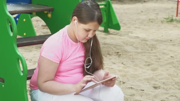 Les enfants utilisent une tablette d'ordinateur, marchent sur l'aire de jeux — Video